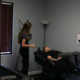 Assistant using tablet to set up a patient on decompression table in wellness room.