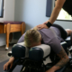 chiropractor gently adjusting the back of a middle aged woman post auto injury for pain relief